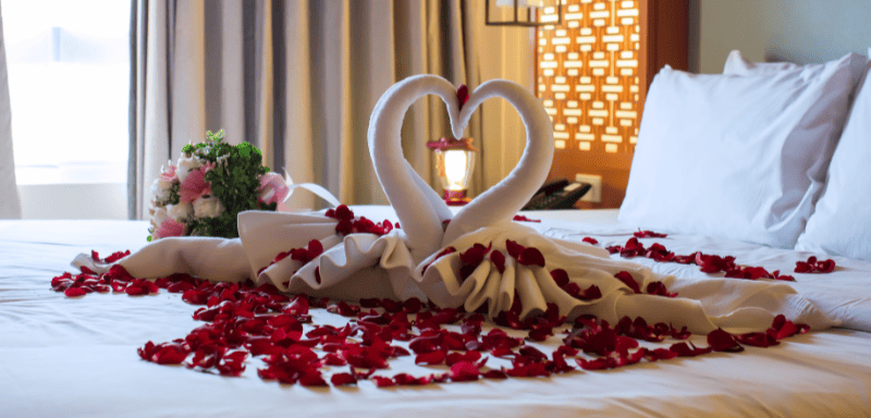 Decoration swans on top of a honeymoon bed.