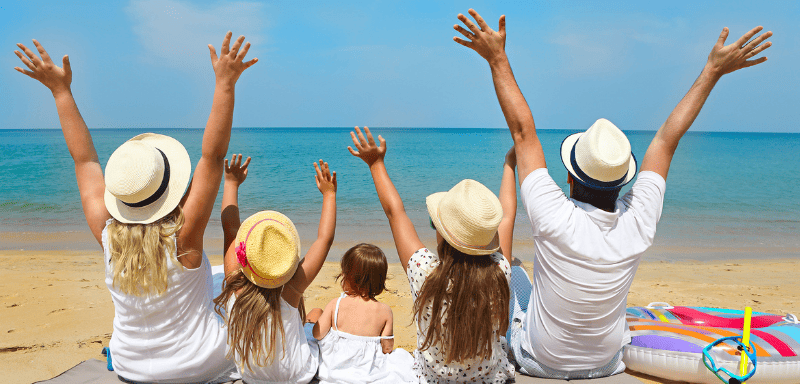 Family sitting on the beach, happy.