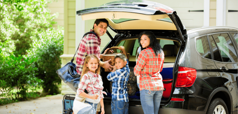 Family packing their bags in the car to travel.