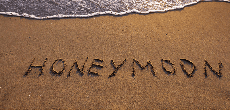 Honeymoon written in the beach sand.