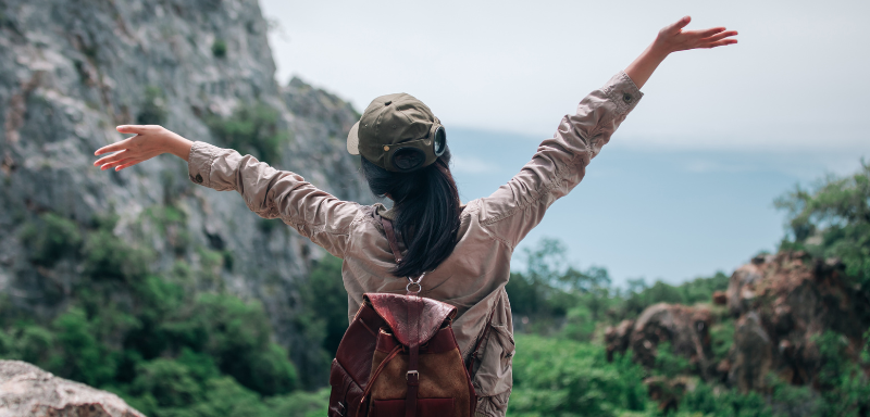 Woman traveling alone, in natural landscape.