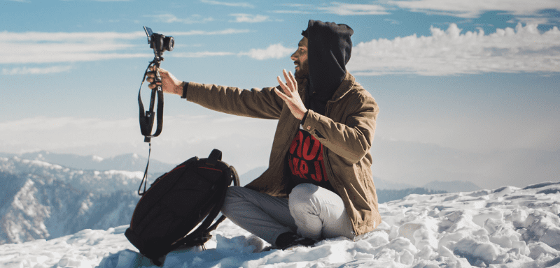 Man in the snow talking to the camera.